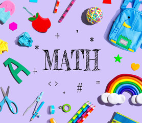 Math theme with school supplies on a purple background - flat lay