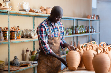 Young Afro male ceramist working in his pottery workshop