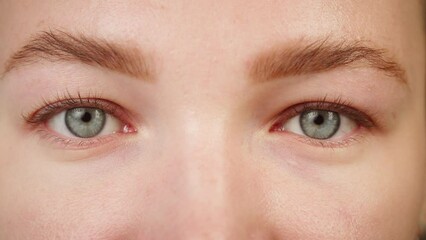 Close-up of a light-blue eye blinking, opening and closing eyes. Advertising of everyday contact lenses for vision improvement. Optical shop, health care and medicine concept.