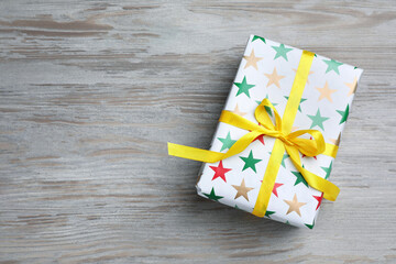 Beautifully wrapped gift box on wooden table, top view. Space for text