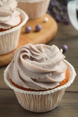 Tasty cupcake with cream on table, closeup view