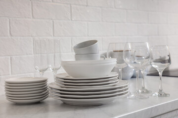 Different clean dishware, cups and glasses on countertop in kitchen