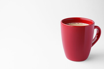 Red mug of freshly brewed hot coffee on white background, space for text