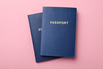 Blank blue passports on pink background, flat lay