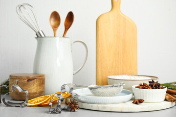 Cookie cutters, ingredients and crockery on white table. Christmas biscuits