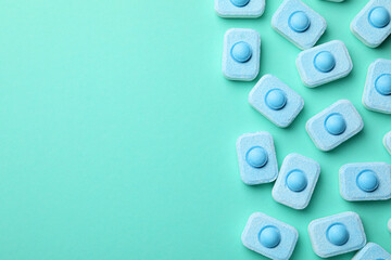Water softener tablets on turquoise background, flat lay. Space for text