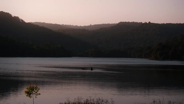 Mountain Viewpoint and Reservoir Phu Pha Daen Forest Park At sunset there are people rowing fishing boats.