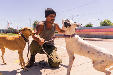Latino man arguing with his pets, two mongrel dogs in Managua, Nicaragua