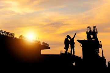 Silhouette of Engineer and worker with clipping path checking project at building site background, Infrastructure construction site at sunset in evening time