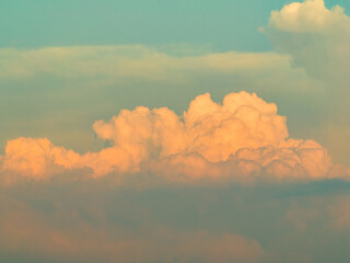 Sunset red glow on billowing cloud through atmospheric haze