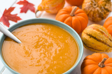 A bowl of pumpkin soup with mini pumpkins