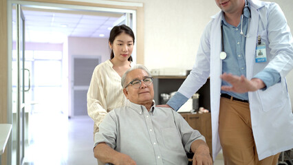 Obraz premium Granddaughter take her grandfather on wheelchair see the doctor or therapist at hospital.