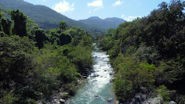 Aerial of a mountain river stream in jungle rainforest. Beautiful scenery of Jarabacoa, Dominican Republic
