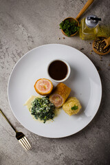 cordon bleu with ham, cheese, cream spinach and smashed potato at white plate on table