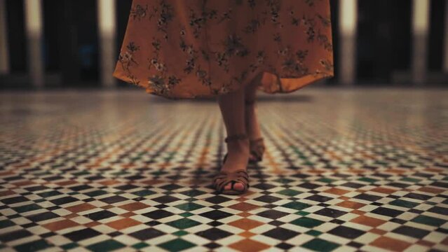 Woman Walking In Slow Motion On A Tile Floor Wearing A Summer Orange Dress Indoors