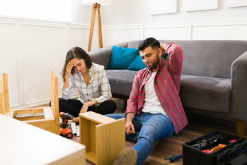 Frustrated couple having problems while assembling furniture