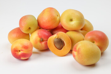 Fresh ripe juicy yellow orange red apricot fruit pile whole cut half slice seed on white background