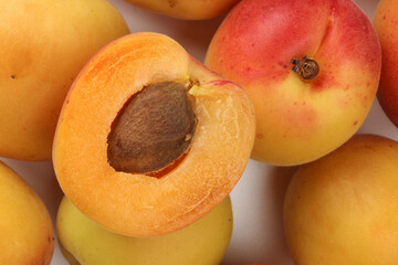 Fresh ripe juicy yellow orange red apricot fruit pile whole cut half slice seed on white background flat lay top view