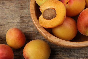 Fresh ripe juicy yellow orange red apricot fruit pile whole cut half slice seed in wooden bowl on rustic wood background flat lay top view