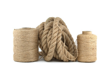 Jute rope and spools of burlap threads over white