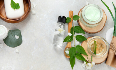Aloe vera slices and moisturizer on a light background.