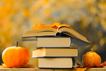 Back to school.Autumn thematic reading. Books and pumpkins in autumn garden.Start school and...