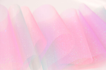 Fabric background.Tulle fabric.iridescent gradient texture.Shiny pink fabric with gradients....