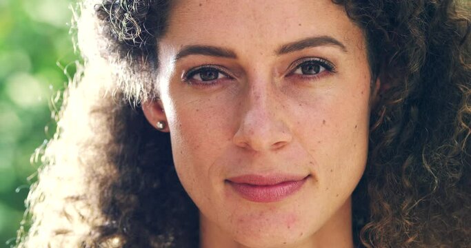 Beautiful woman looking confident, serious and natural while outdoors during the day. Portrait of the face and head of an attractive female standing outside with a blank expression on a summer day