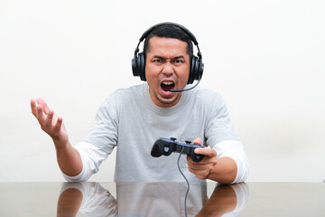 Asian man showing rage expression when playing game