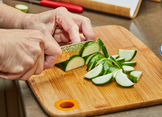 Chef cuts the zucchini into semicircles to prepare the dish