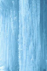 Obraz premium Vertical background of icicles on frozen waterfall wall.