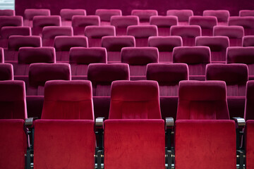 Empty red chairs for audience in the theater