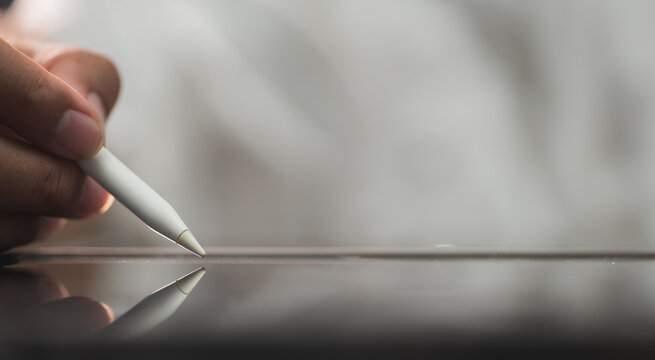 Close up hand of business person sign the signature on the contract agreement document on free right space tablet computer in the office. Cyberspace technology concept.