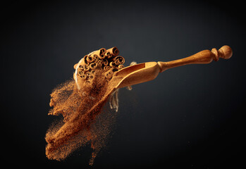 Cinnamon powder is poured out of the wooden spoon.