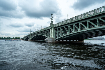 Bridge. A low metal bridge across the river in cloudy weather in gloomy dark colors. St. Petersburg
