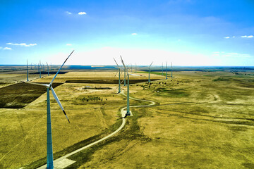 wind power plant in the steppe against the blue sky shooting from a drone