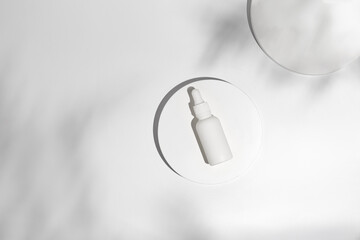 Mockup of beauty cosmetic makeup bottle with pipette on white round podium with shadow. Minimal cosmetic background for product presentation. Blank cosmetics Bottle.