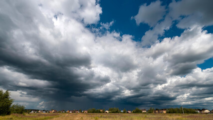 Rain clouds over the village. Heavy rain in the village in summer
