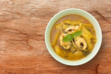 Green Taro curry with fish in green bowl on wooden board background , thai food concept , top view , flat lay.