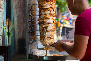 Chef cutting with doner knife Traditional Turkish Doner Kebab meat.