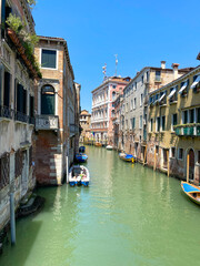 Fototapeta na wymiar The view of the calm canal with boats, Venice, Italy