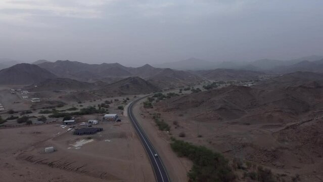 Aerial rising from road between mountains near Al Lith hot spring, Saudi Arabia