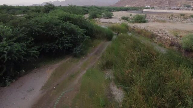 Aerial flying forward over Al Lith hot spring revealing road and mountains