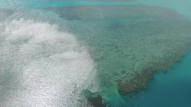 Sunlight reflecting over ocean water surface of Whitsundays islands at Shute Harbour in Australia. Aerial drone pov