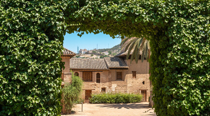 Fototapeta na wymiar Arco formado por un seto podado dentro del recinto monumental de la Alhambra en Granada, España