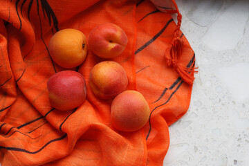 Several ripe apricots on an orange background