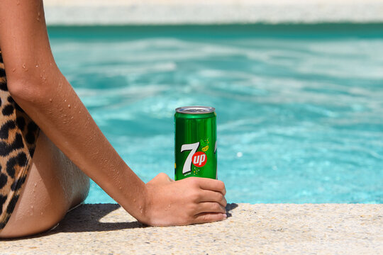 Novorossiysk, Russia - July 2022: Girl with a can of cold soft drink 7up after swimming in the hotel pool. Copy space, selective focus.