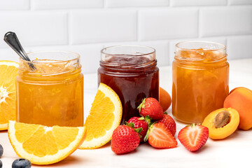 Homemade jam in glass jars at white table