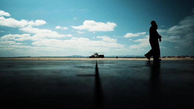 Parked helicopter air base with pilots passing by