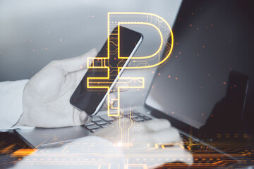 Close up of male hands using laptop and smartphone on desktop with creative glowing Russian ruble hologram on blurry background. Digital money and online banking concept. Double exposure.